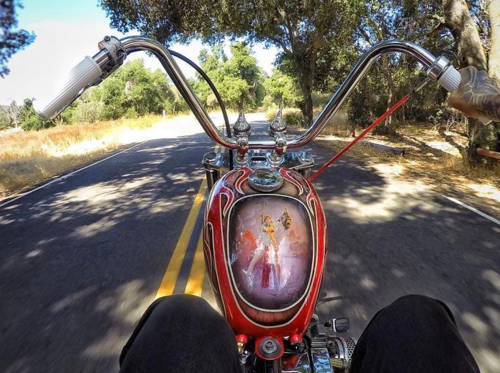 White Pangea Speed Ronald grips installed on chrome chopper handlebars, viewed from the rider's seat
