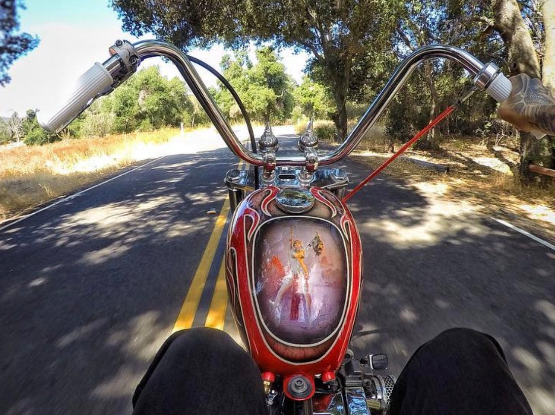 White Pangea Speed Ronald grips installed on chrome chopper handlebars, viewed from the rider's seat